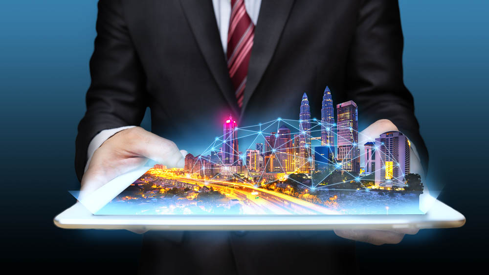 A person in a suit holds a tablet with a holographic cityscape emerging from the screen, its digital design reflecting the seamless integration of technology and connectivity. The scene subtly echoes the secure EcoVadis Certification process, emphasizing sustainable commitment amidst innovation.